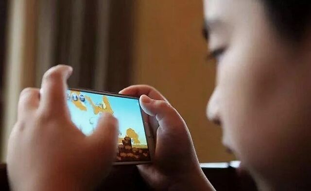 小孩子打游戏照片_小孩拿着手机打游戏图片_小孩拿图片打手机游戏视频